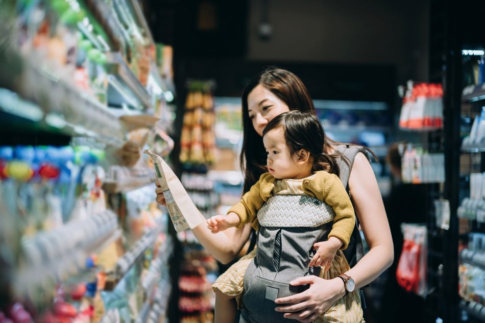 Woman checking an Amcor package in a supermarket